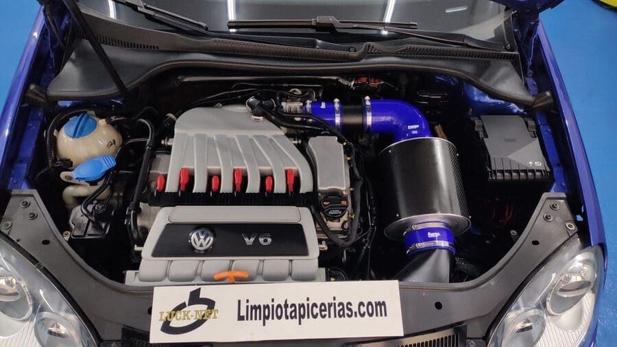 Un coche azul con el capó levantado y un cartel que dice limpiotapicerias.com