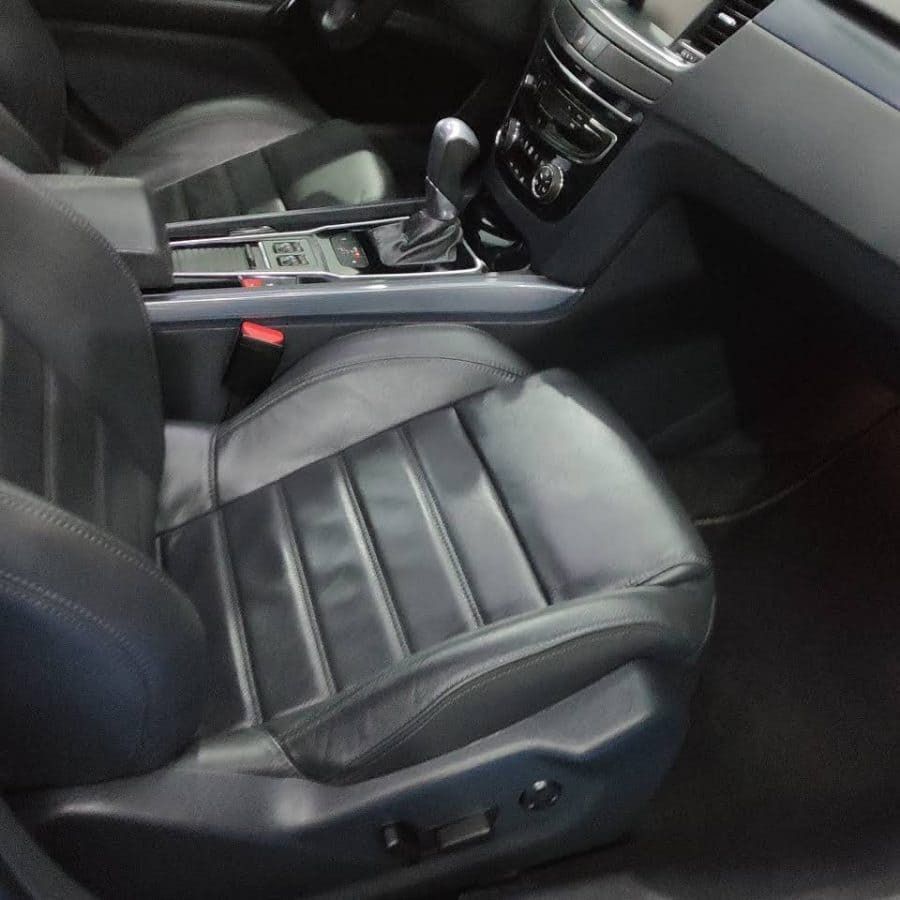 El interior de un coche con asientos de cuero negro.