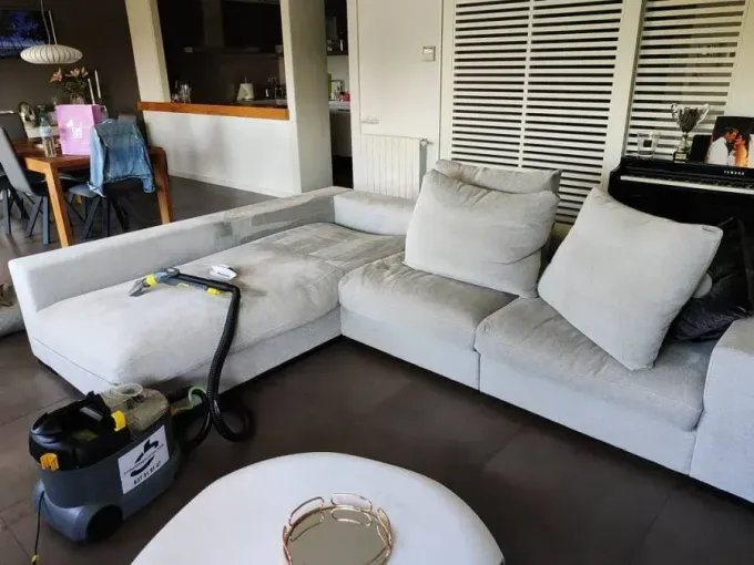 Una sala de estar con un sofá y una aspiradora.