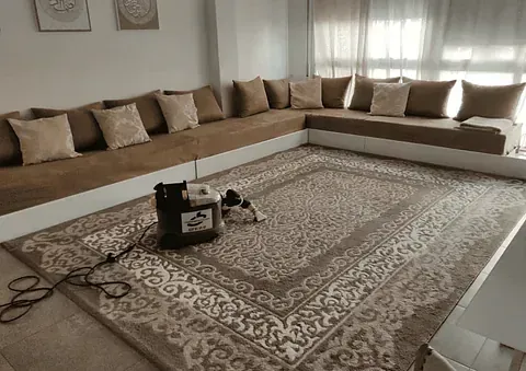 Una sala de estar con una alfombra grande y un sofá.
