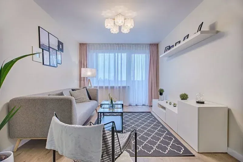 Una sala de estar con sofá, silla, mesa y alfombra.