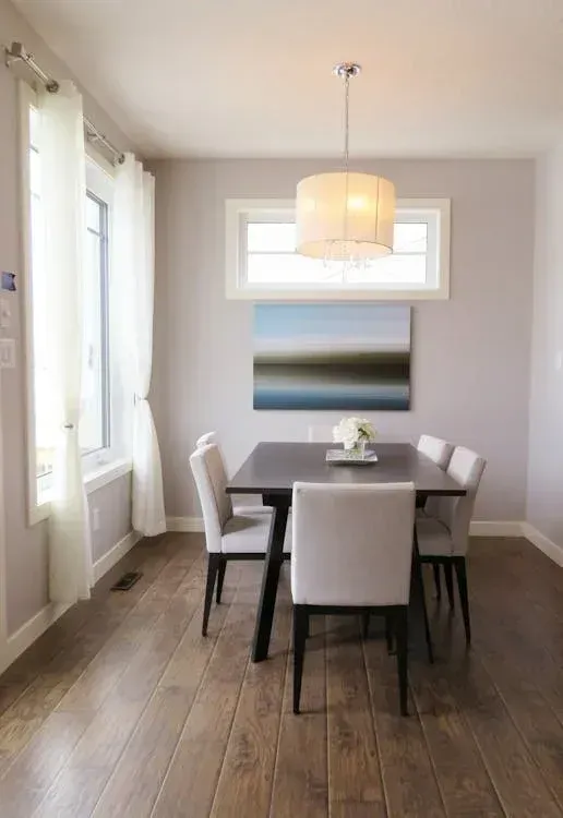Un comedor con una mesa y sillas y un cuadro en la pared.