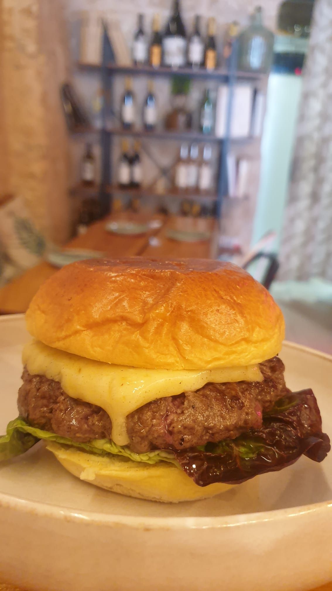 Un primer plano de una hamburguesa en un plato sobre una mesa.