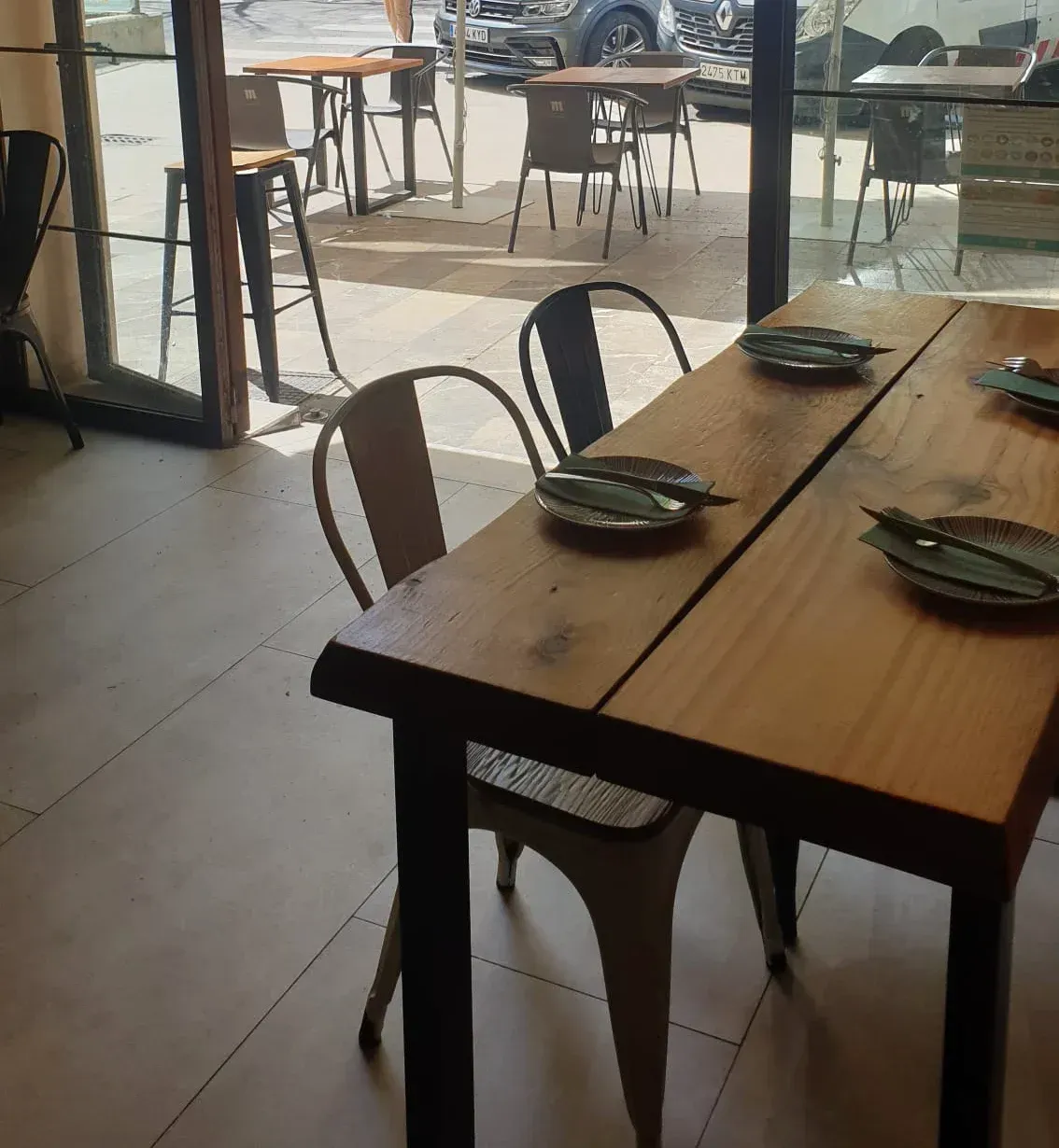 Un restaurante con mesas, sillas y platos.