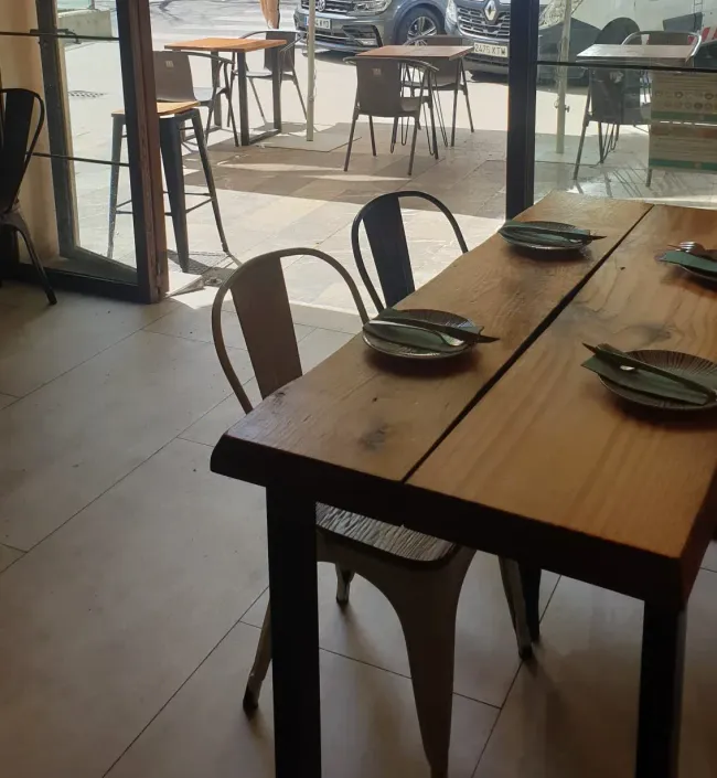 Un restaurante con mesas, sillas y platos.