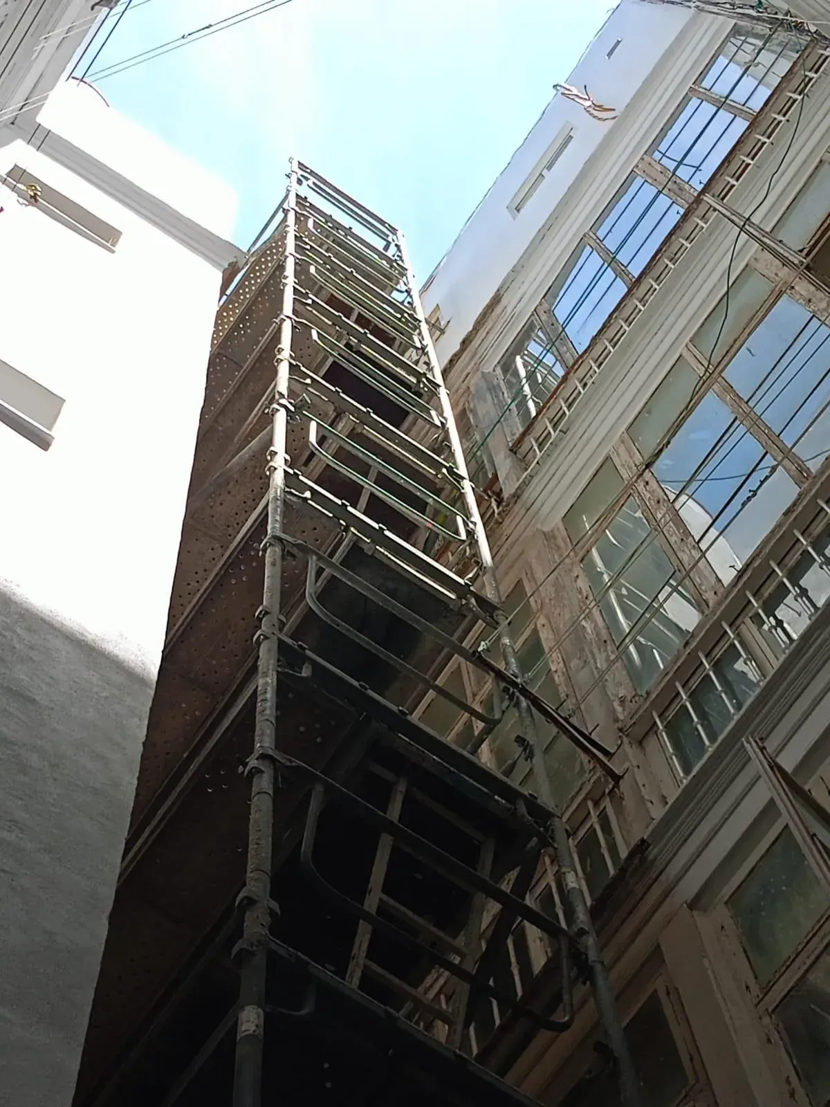 Andamio erigido entre dos edificios, que se extiende hacia el cielo.