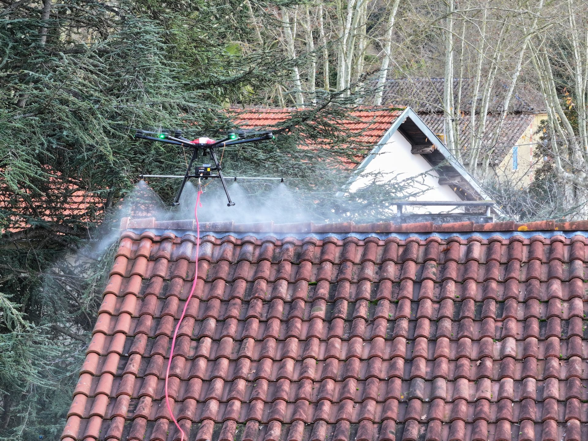 Drone qui pulvérise un traitement d’émoussage sur une toiture