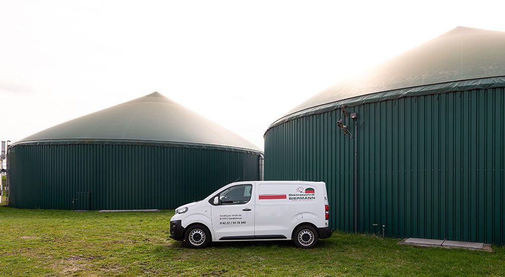 Ein weißer Lieferwagen parkt vor einem grünen Gebäude.