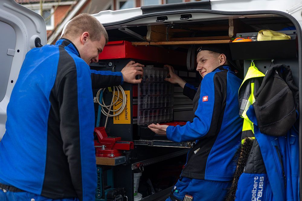 Zwei Männer arbeiten hinten in einem Lieferwagen.