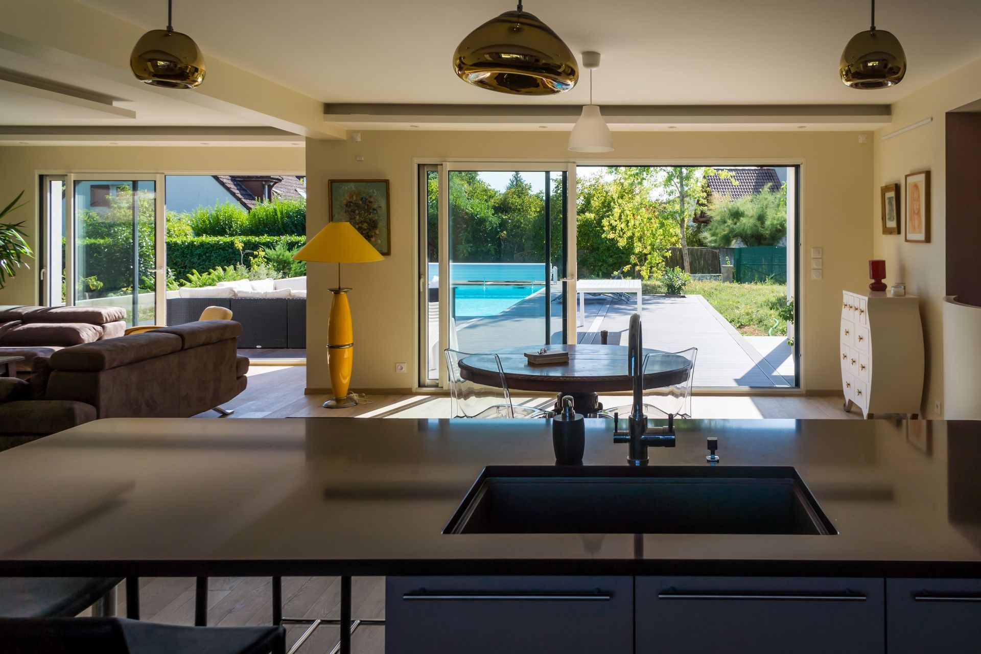 Intérieur de cuisine moderne avec un îlot central et un évier foncés.