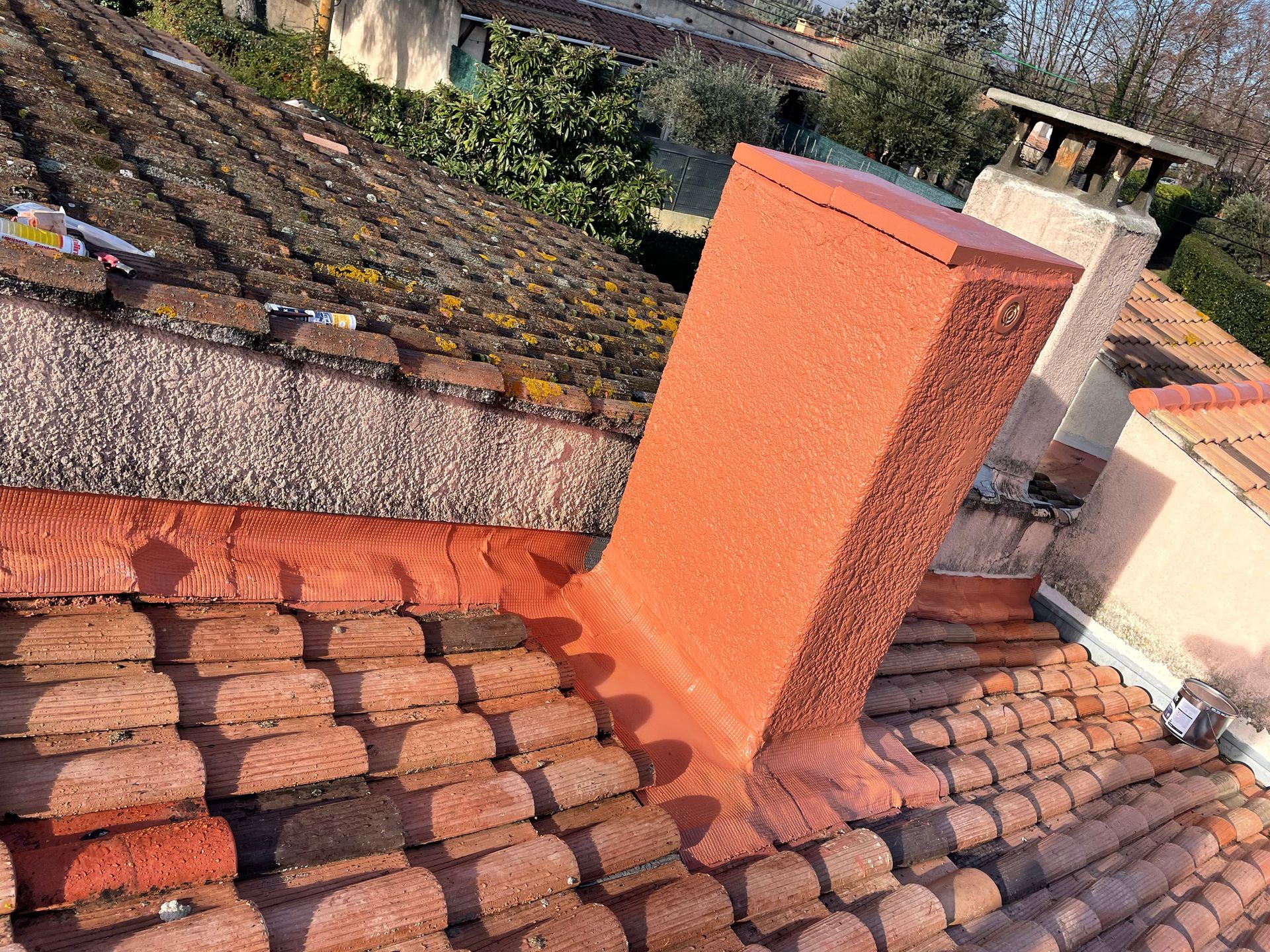 Cheminée rouge sur un toit en tuiles