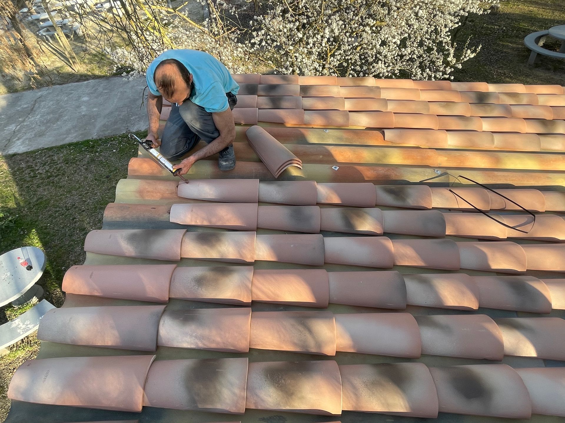 Ouvrier sur un toit changeant des tuiles cassées