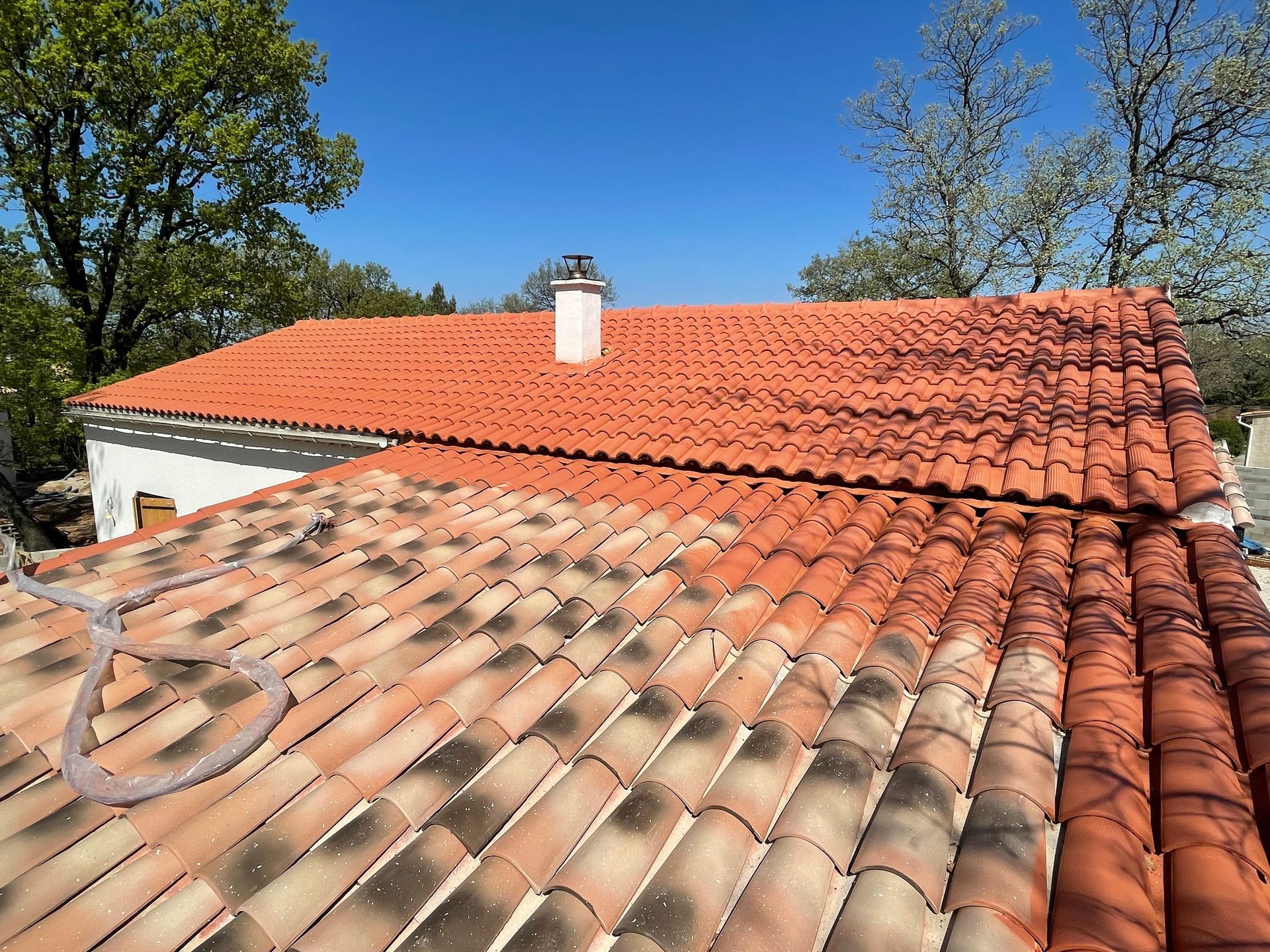 vue d'un toit en tuiles dont la parties haute est recouverte de peinture hydrofuge