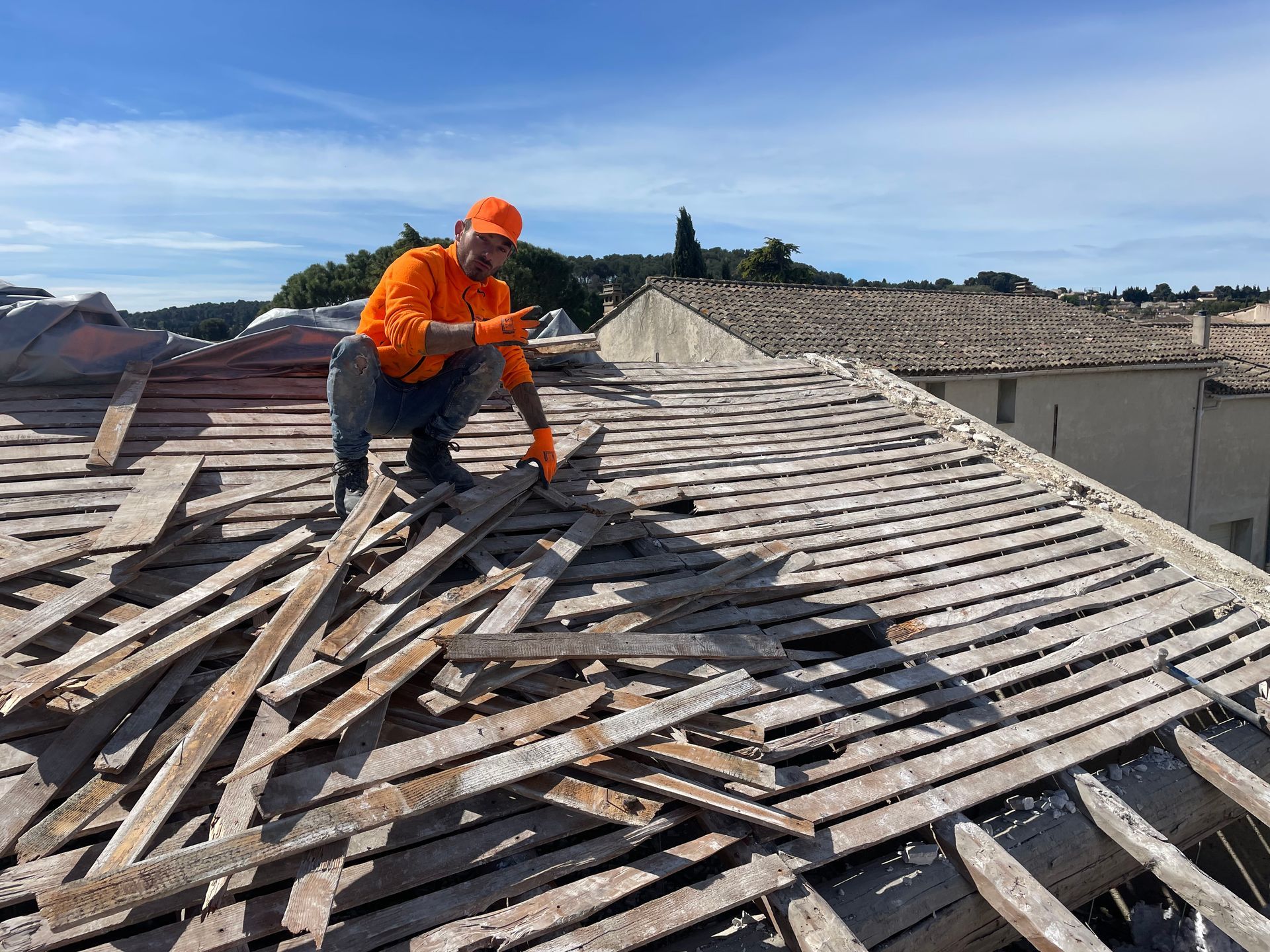 Homme sur un toit dont la charpente est détruite
