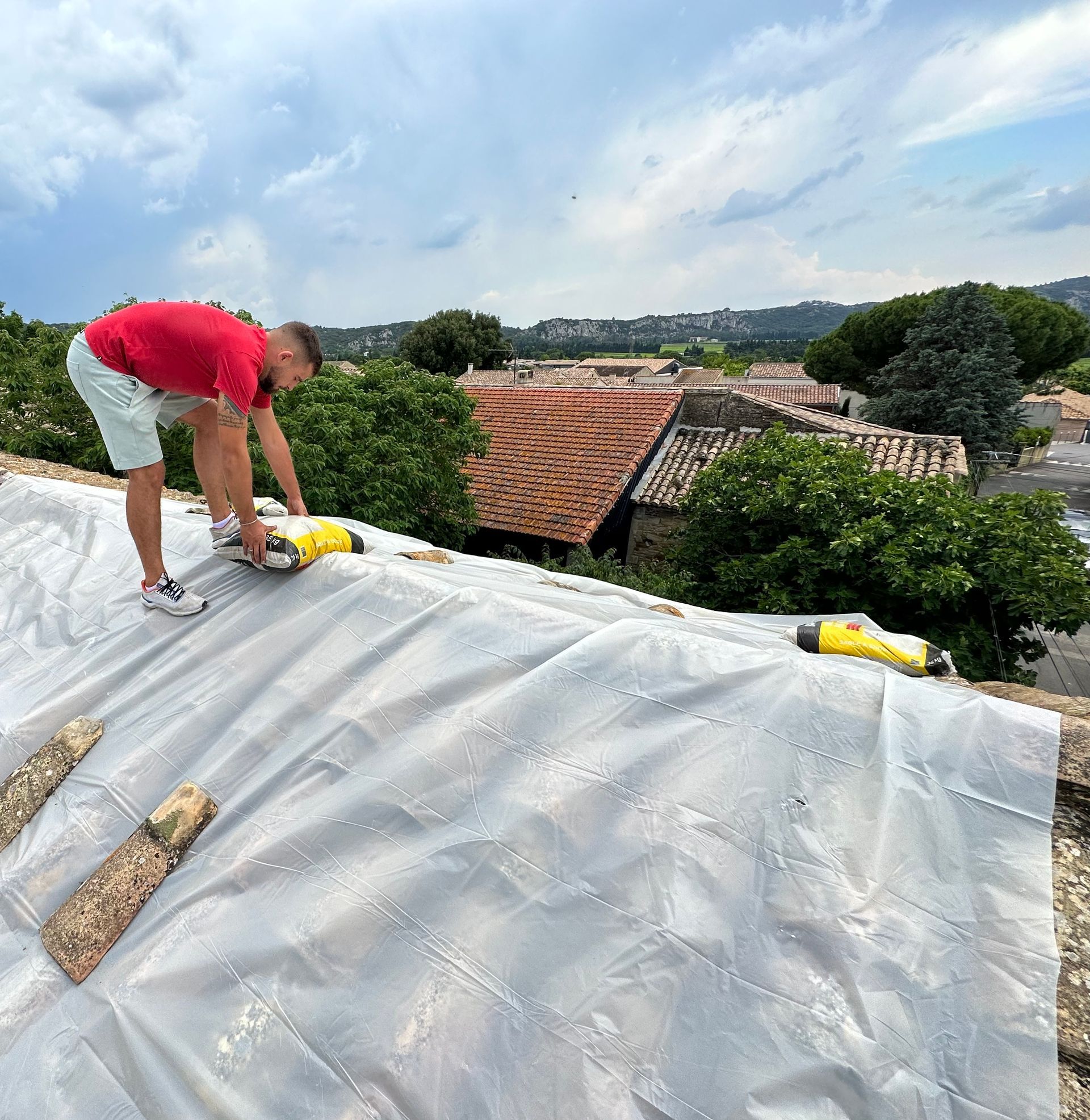 Ouvrier sur un toit sur lequel une bâche transparente est posée