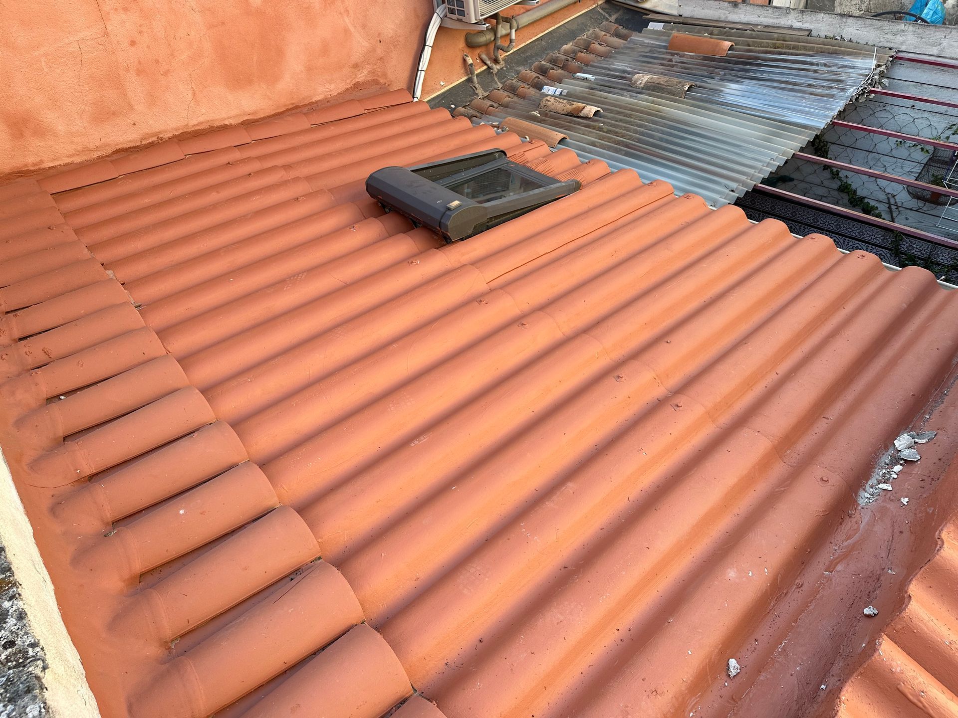 Fenêtre de toit dans une toiture en tuiles rouges