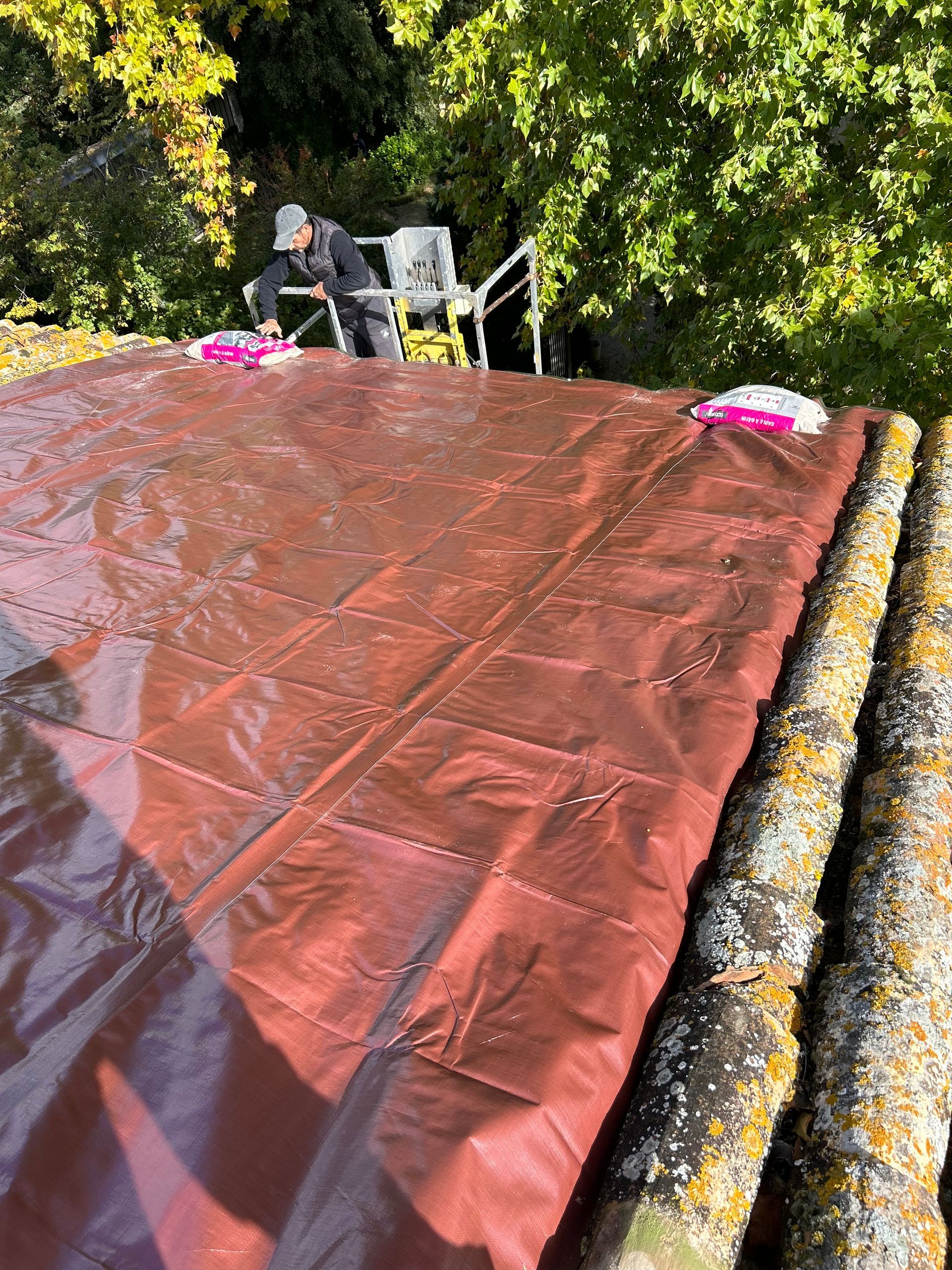 Grande bâche rouge de protection sur un toit