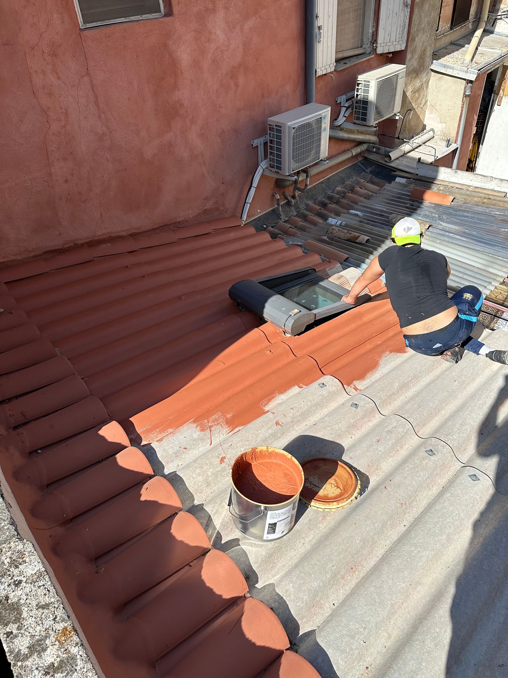 Pose d'une fenêtre de toit par un ouvrier assis