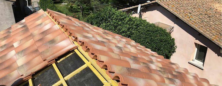 pose des tuiles sur une charpente encore visible