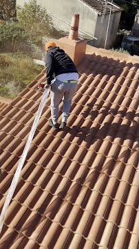 vue d'un ouvrier de dos tenant un tuyau de diffuseur de peinture hydrofuge