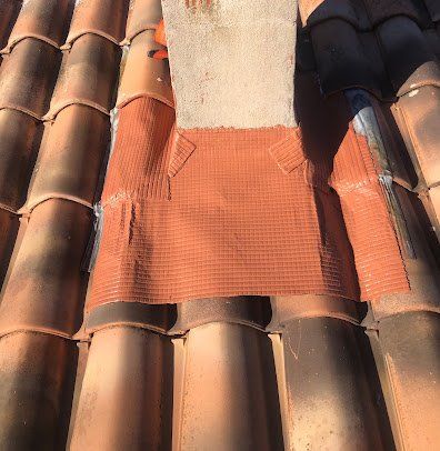 Installation de solin d'étanchéité sur tout le tour du pied de cheminée