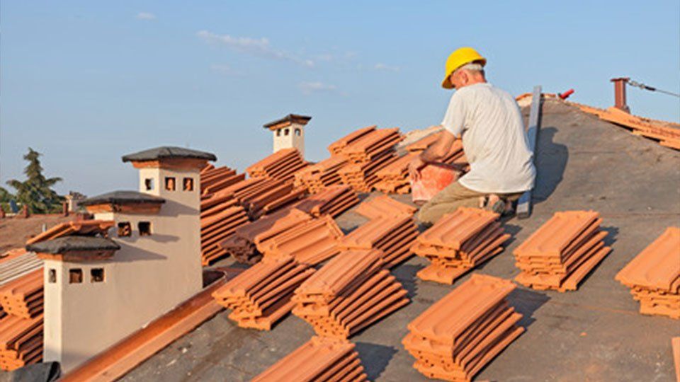Homme installant des tuiles sur un toit