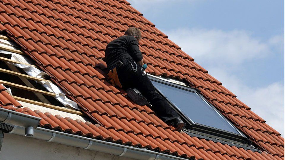 Homme installant une fenêtre de toit