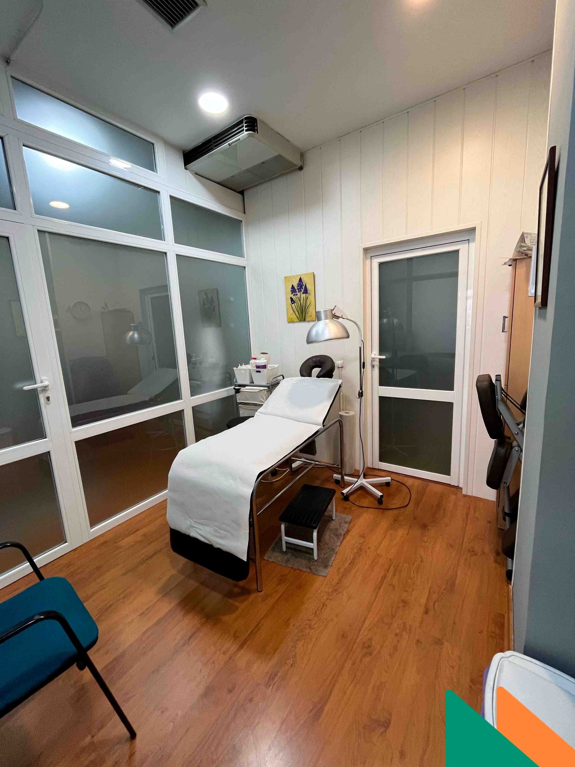 Un consultorio médico con una cama y sillas