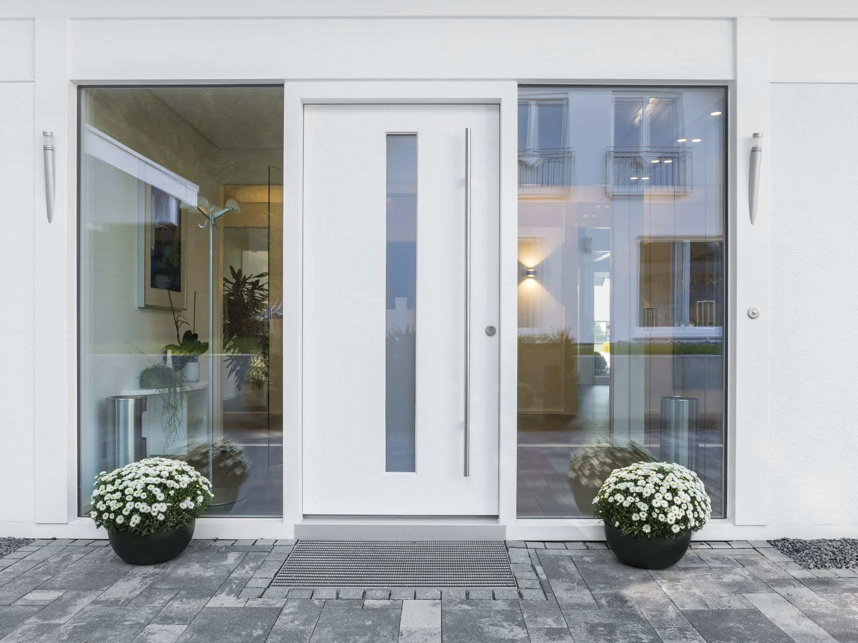 Porte d'entrée blanche avec une partie vitrée.