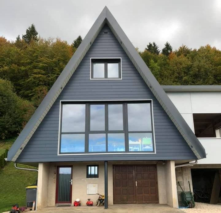 Façade d'une maison individuelle avec un bardage en bois et des menuiseries en alu.
