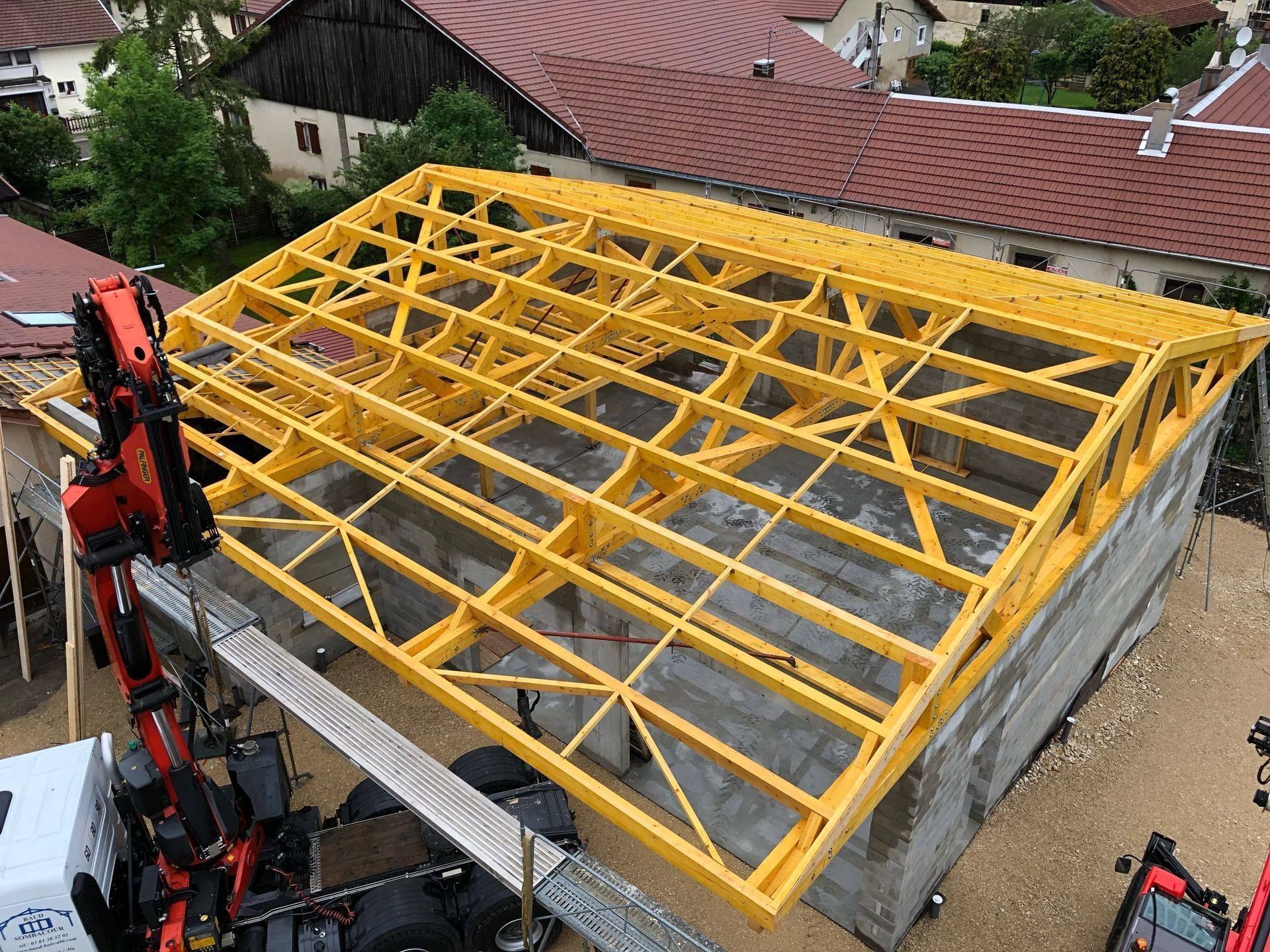 Vue sur une charpente en bois posée dans une maison.