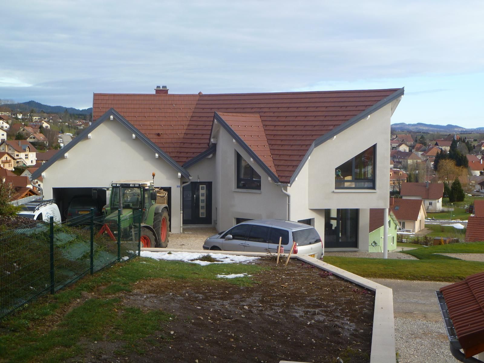 Une maison avec la toiture en tuiles plates.