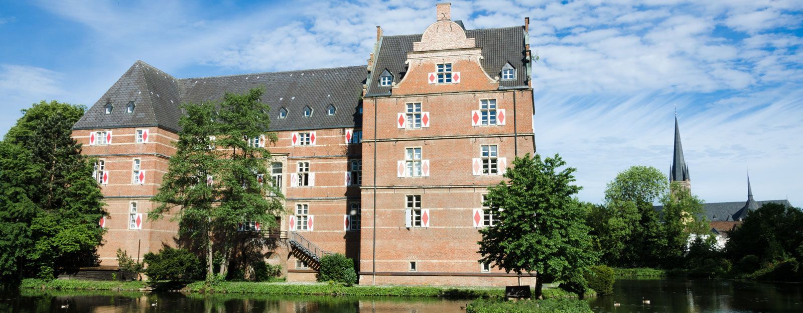 Ein großes Backsteingebäude steht neben einem Gewässer