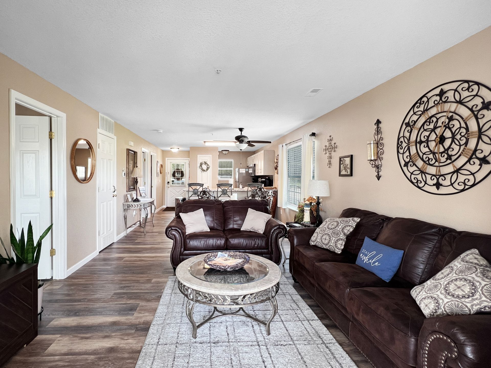 A living room with two couches , a coffee table , and a ceiling fan.