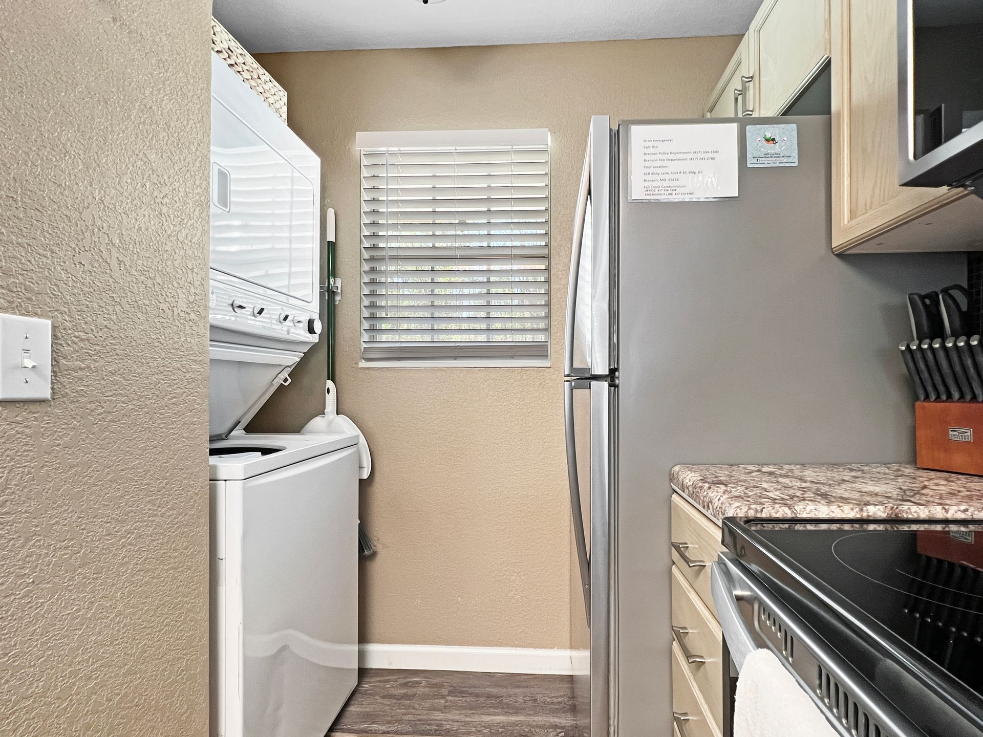 A kitchen with a washer and dryer and a refrigerator