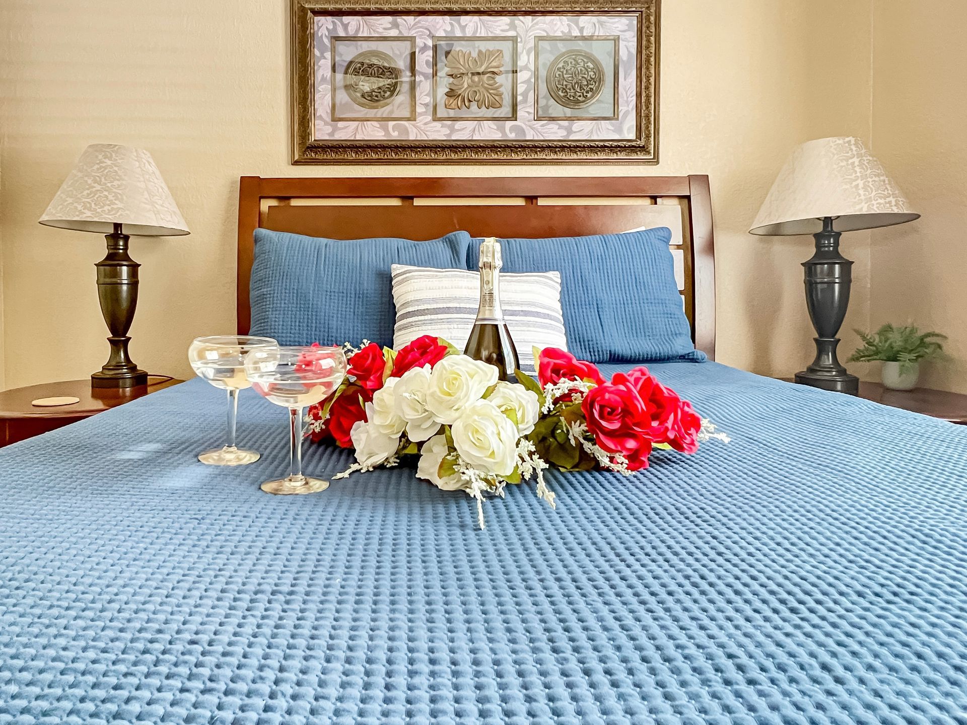 A bed with flowers and a bottle of champagne on it