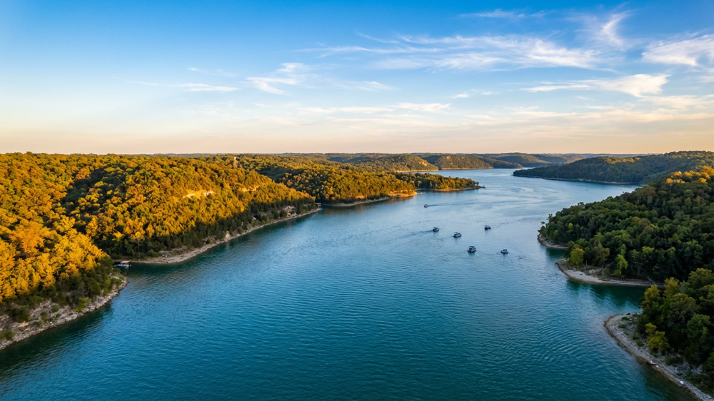 Aerial view of Table Rock Lake at golden hour showing crystal-clear Ozark water, wooded shoreline, a