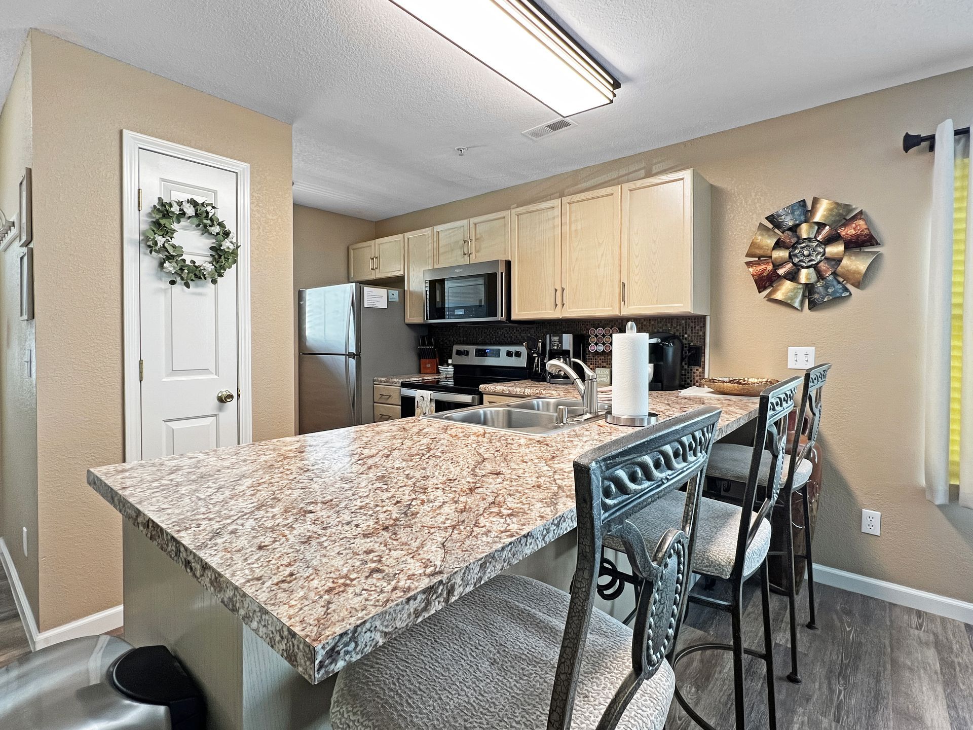 A kitchen with granite counter tops and stainless steel appliances.
