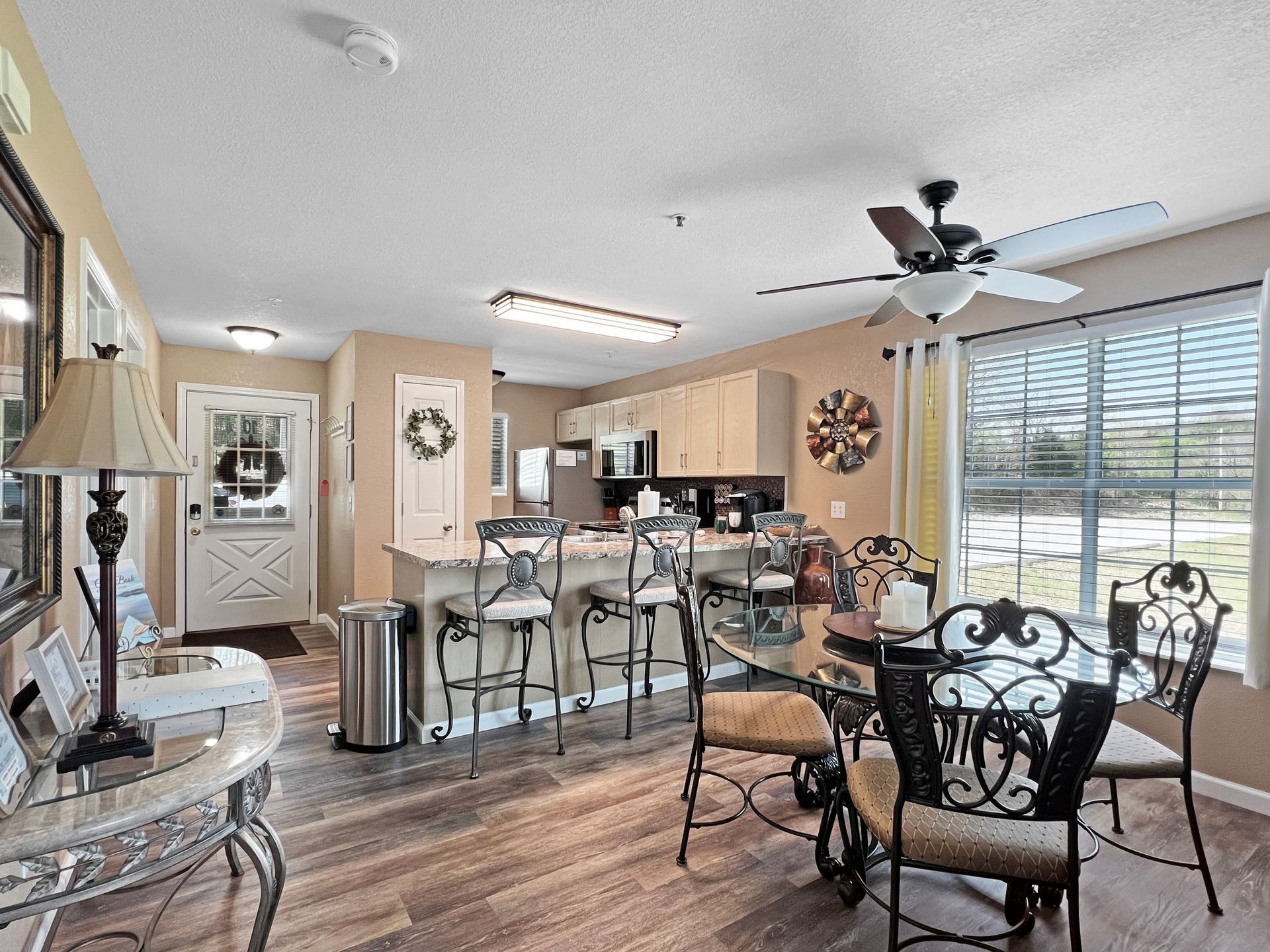 A living room with a table and chairs and a ceiling fan.