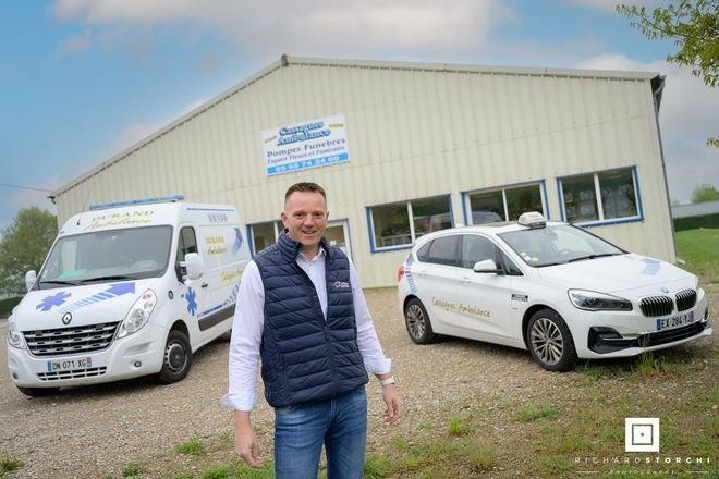 M. Durand devant les locaux de son entreprise