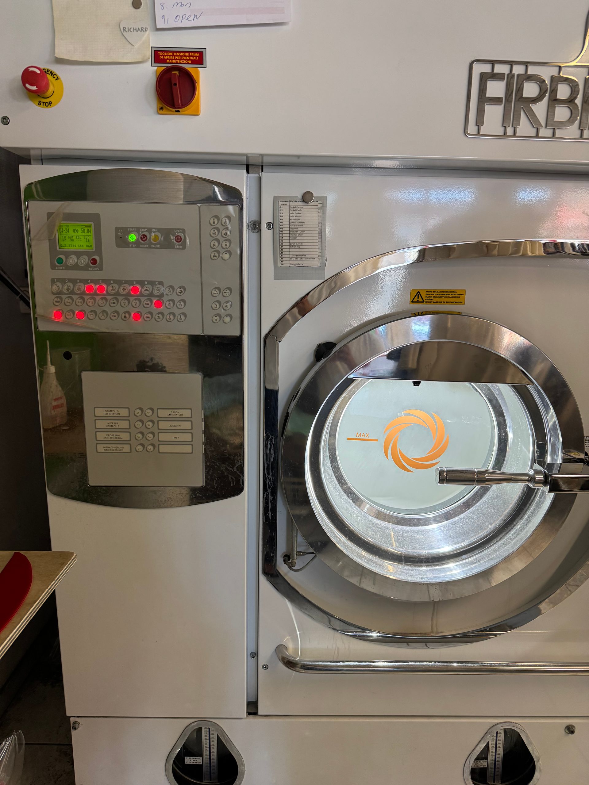 Industrielle Trockenreinigungsmaschine mit offener Tür und Bedienfeld.