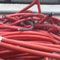 Un montón de cables rojos están colocados uno encima del otro sobre una mesa.