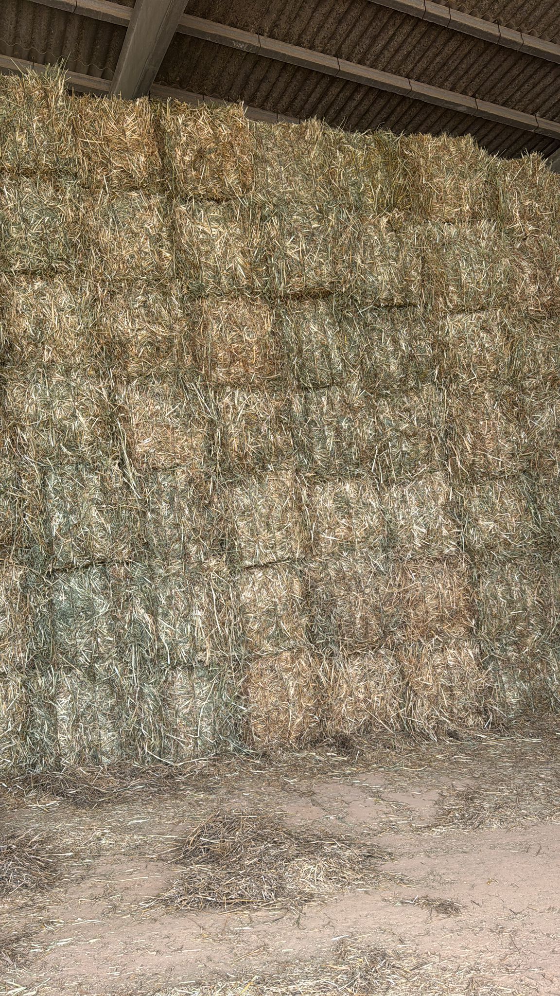 Una gran pila de heno se apila una encima de otra en un granero.