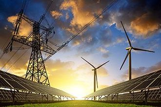 Ein Feld aus Solarmodulen und Windturbinen mit Stromleitungen im Hintergrund bei Sonnenuntergang.