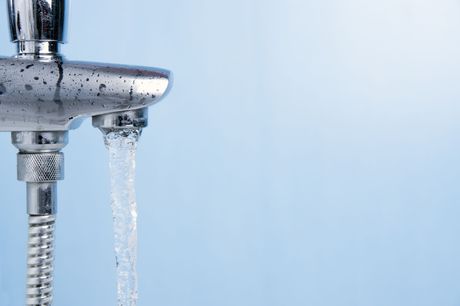 Zwei Wasserhähne, aus denen Wasser kommt, auf blauem Hintergrund