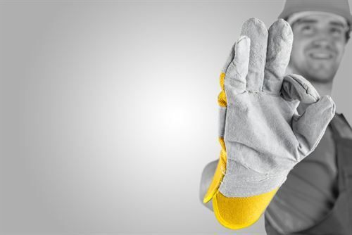 Ein Mann mit Schutzhandschuh gibt ein OK-Zeichen.