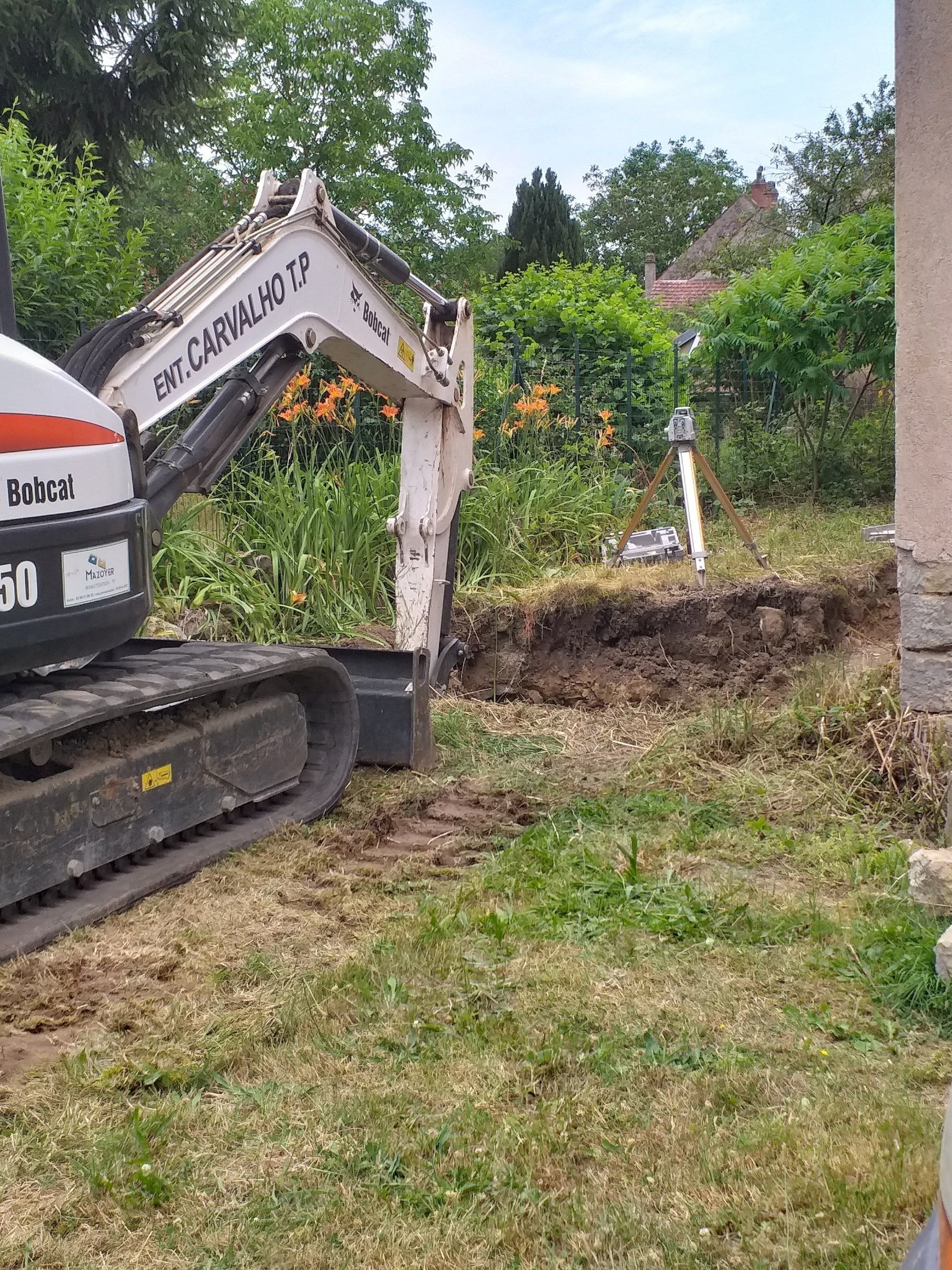 Excavateur en action sur un chantier de construction d'une maison