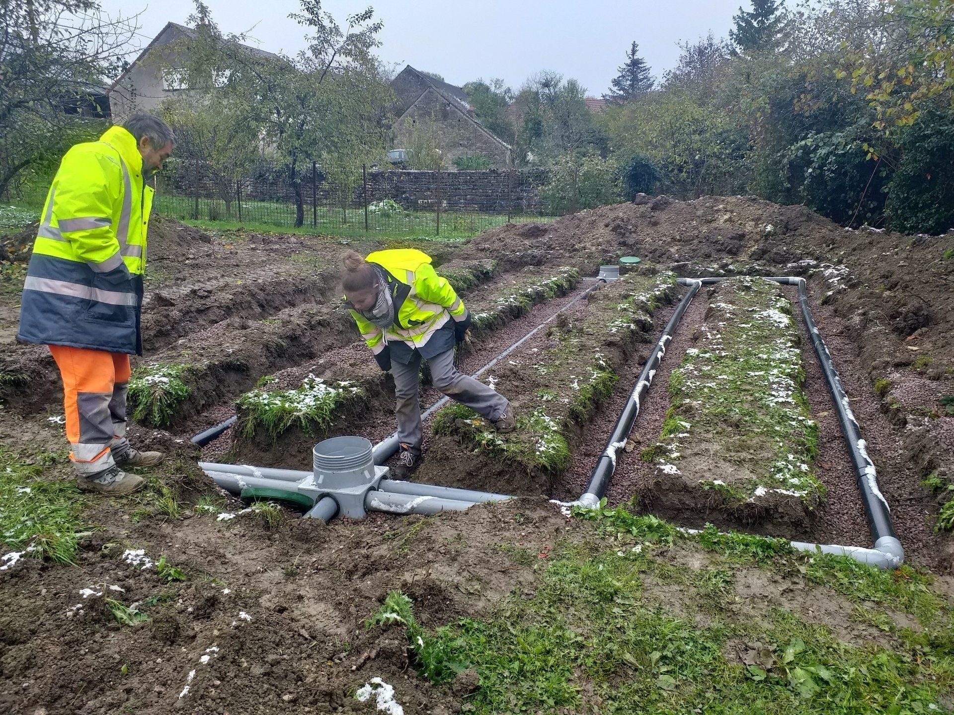 Deux personnes travaillent sur un réseau d'assainissement