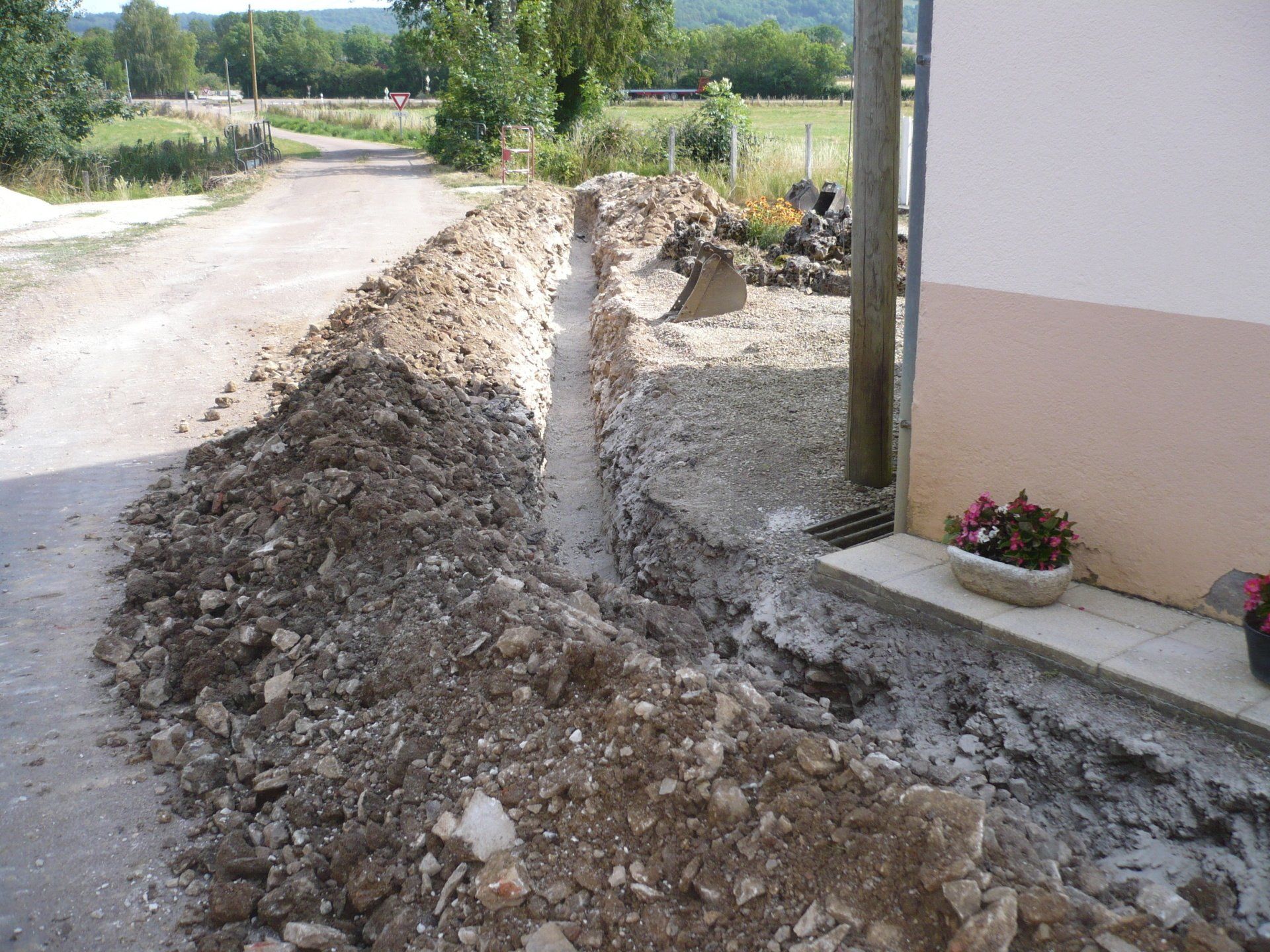 Tranchée d'assainissement devant une maison
