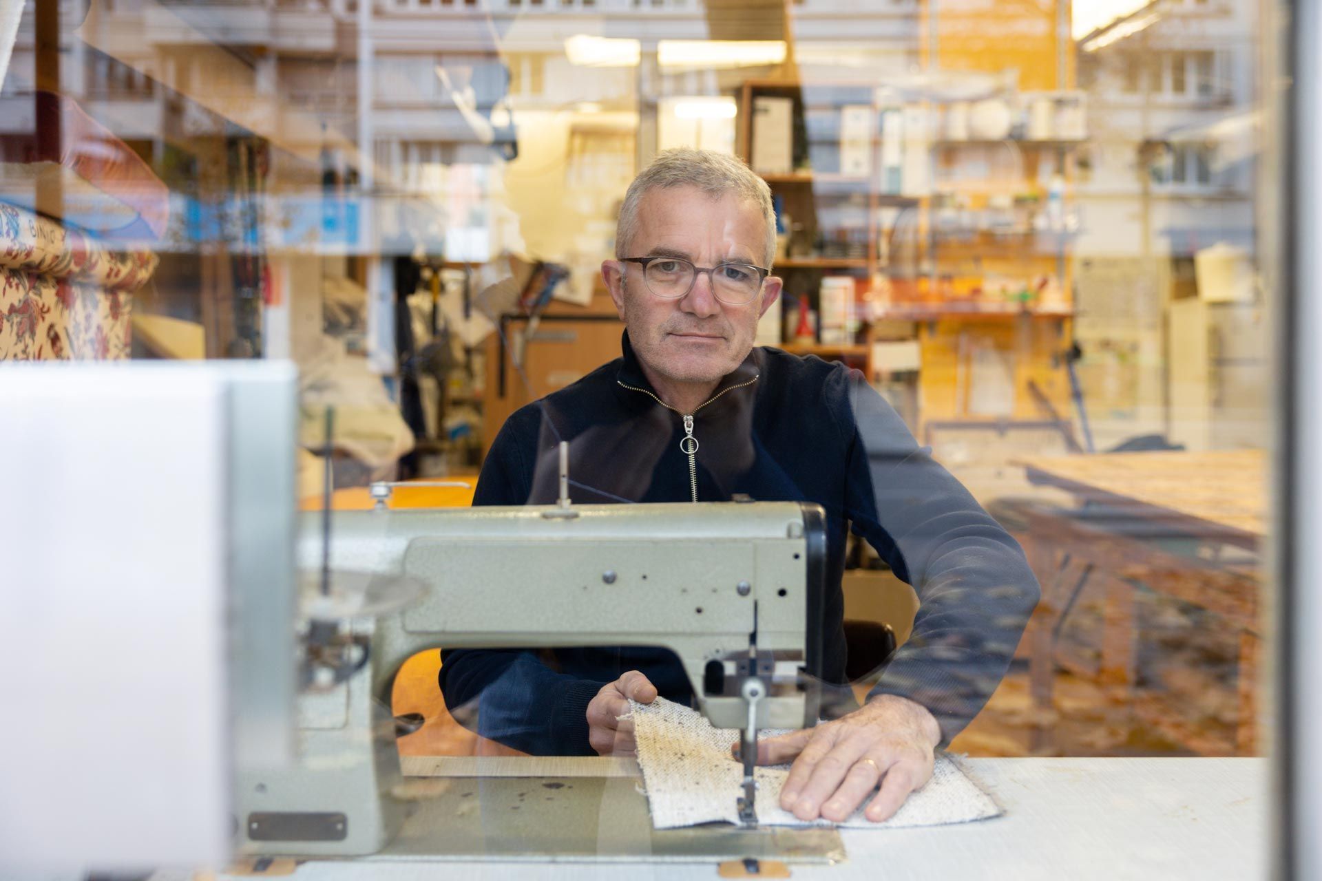 Un couturier-tapissier devant sa machine à coudre